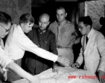 VIPs from both the US and China talk things over during WWII at a base somewhere in China.  Senator Henry Wallace gestures over the map, next to Chiang Kai-shek.