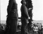 Chinese Lt. General Du Yuming, commander of Nationalist 5th Corps (第五集团军总司令兼昆明防守司令杜聿明) looks out at troops, with Gen. Wei Lihuang (卫立煌) facing assembled troops, and another person holding a sheet of paper, on stage during rally.