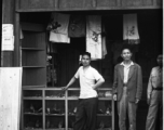 Men at the door of a small store in Yunnan, China, possibly near an American base at Luliang or Chanyi (Zhanyi). During WWII.