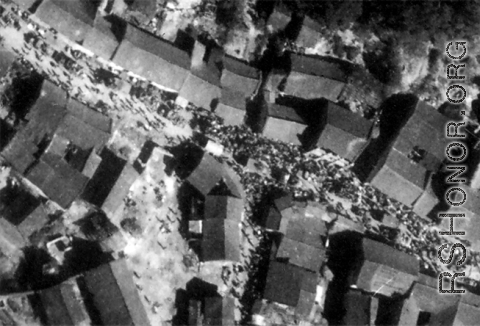 The town densely crowded with trucks, munitions, and artillery in a convoy, as well as dense crowds of Chinese civilians, seconds before the bombs hit.