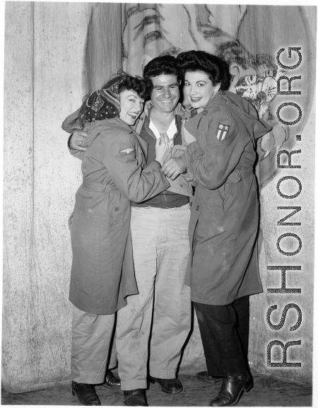 Celebrities visit and perform at Yangkai, Yunnan province, during WWII: Happy GI poses with two starlets 0n the stage at Last Resort.