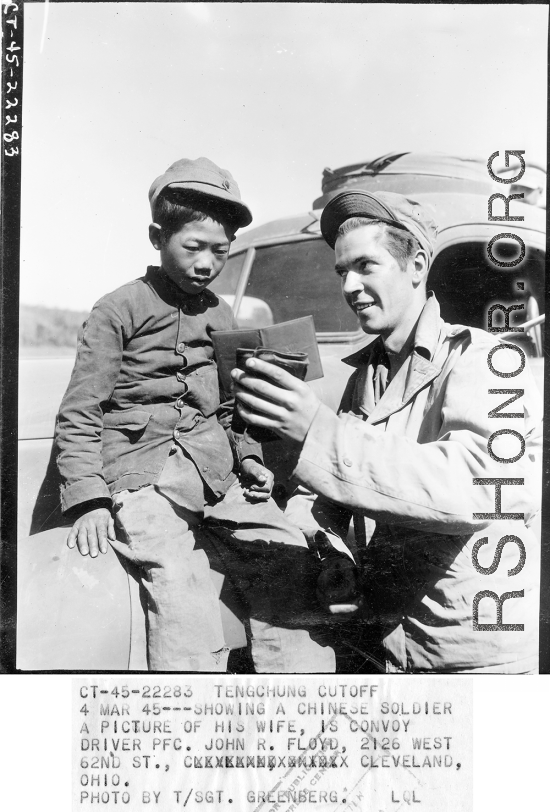 At the Tengchong cutoff: Convoy driver Pfc. John R. Floyd shows a kids a picture of his wife.  Yunnan Province on March 4, 1945.  Photo by T/Sgt. Greenberg.  Passed by William E. Whitten.