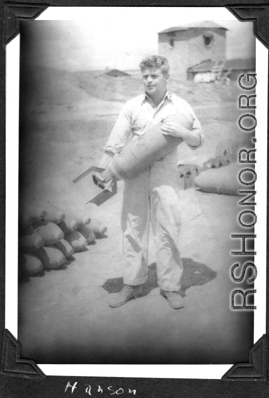 Sam Hansen holds a bomb, probably near Chenggong air base, Yunnan, China. During WWII.