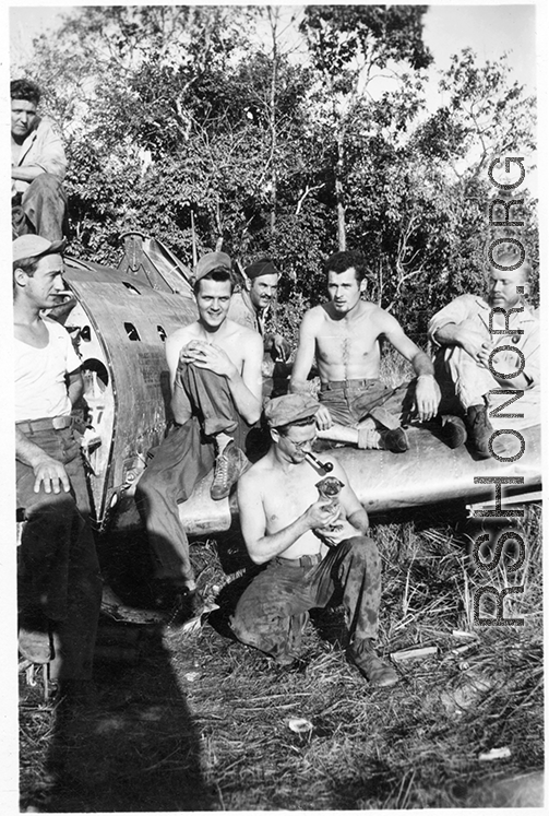 The boys hanging out on remains of fighter plane.  Leo Spearence (with pipe) in center, John Schuhart (far right).  Likely in Burma. 2005th Ordnance Maintenance Company,  28th Air Depot Group.