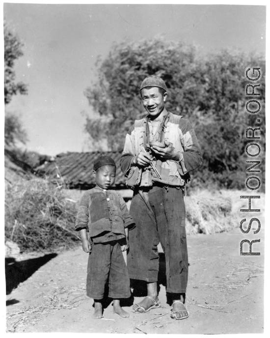 Chinese boy and man at Chanyi (Zhanyi), during WWII, at mealtime.