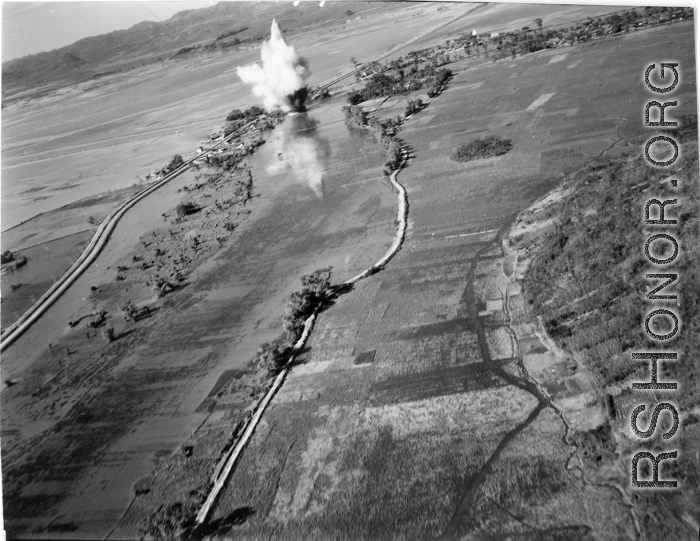 Bombing of small rail bridge, among a flood plain, in French Indochina during WWII.