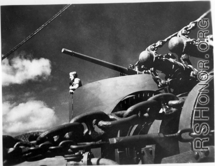 Man with microphone in gun emplacement on transport ship home from CBI to US after WWII.