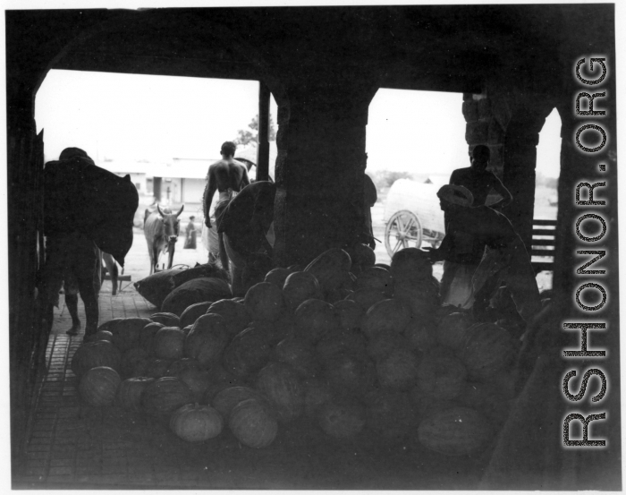 Large pile of melons or pumpkins.  Scenes in India witnessed by American GIs during WWII. For many Americans of that era, with their limited experience traveling, the everyday sights and sounds overseas were new, intriguing, and photo worthy.