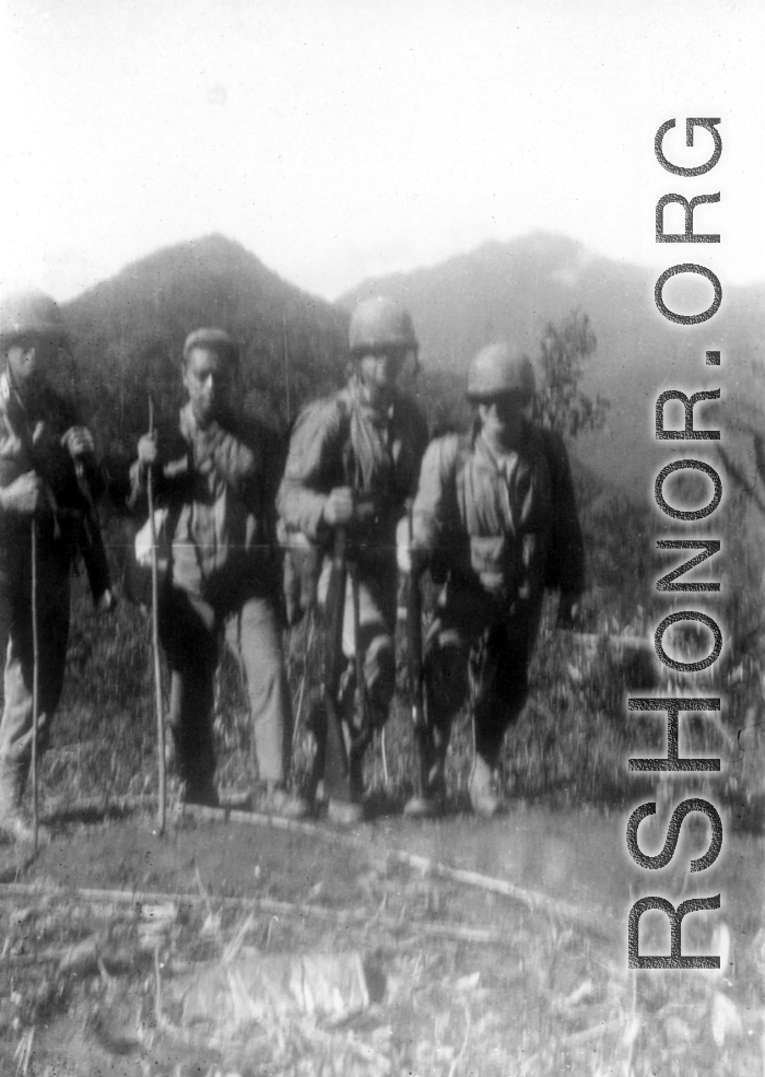 American GIs (and possibly Chinese soldier or interpreter) on mountains near Baoshan, Yunnan, China, during WWII, during battle with Japanese forces.
