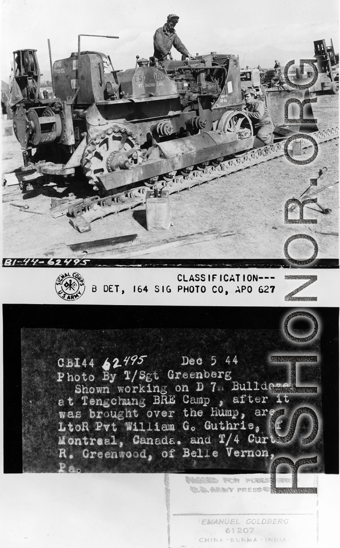 Shown working on D7 Bulldozer at Tengchong BRE Camp, after it was brought over the Hump, are L to R, Pvt. William Guthrie, and T/4 Curtiss R. Greenwood.  Photo by T/Sgt. Greenberg.  Passed by censor Emanuel Goldberg.