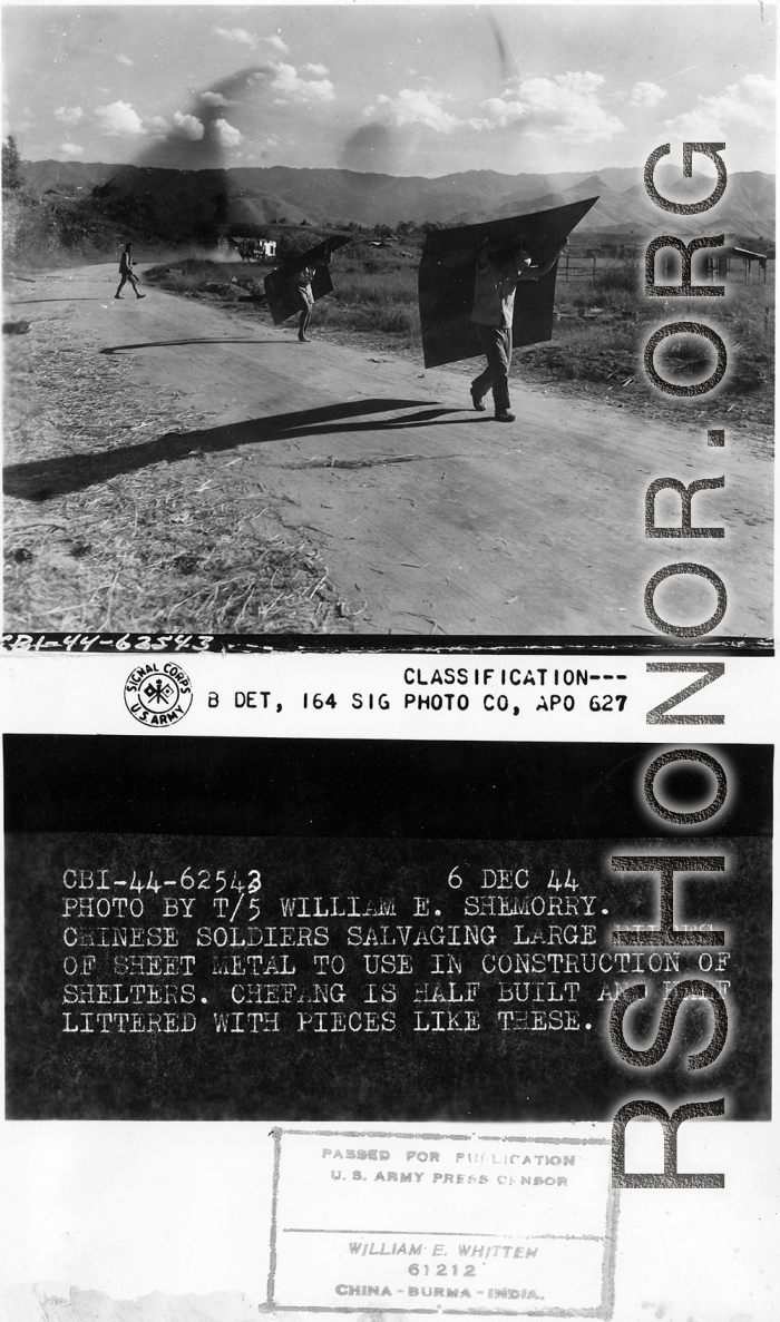 Chinese soldiers salvaging large pieces of sheet metal to sue in construction of shelters. Zhefang is half built and half littered with pieces like this.  December 6, 1944.  Photo by T/5 William E. Shemorry. 164th Signal Photographic Company, APO 627.  Passed by William E. Whitten.