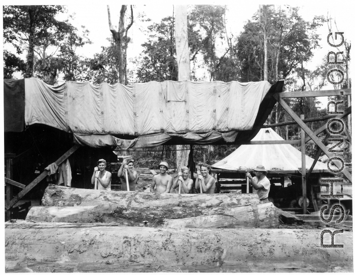 GIs wranging logs towards saw with cant pikes at a lumber mill of the 797th Engineer Forestry Company in Burma.  During WWII.