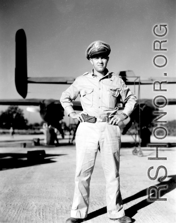 An American flyer in the CBI standing by the tail of a B-25 in the CBI.