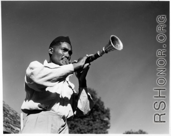 Man blowing horn.  Scenes in India witnessed by American GIs during WWII. For many Americans of that era, with their limited experience traveling, the everyday sights and sounds overseas were new, intriguing, and photo worthy.