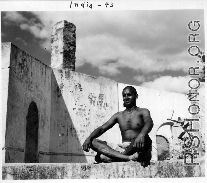 Man sitting cross-legged in India in 1943.  Scenes in India witnessed by American GIs during WWII. For many Americans of that era, with their limited experience traveling, the everyday sights and sounds overseas were new, intriguing, and photo worthy.