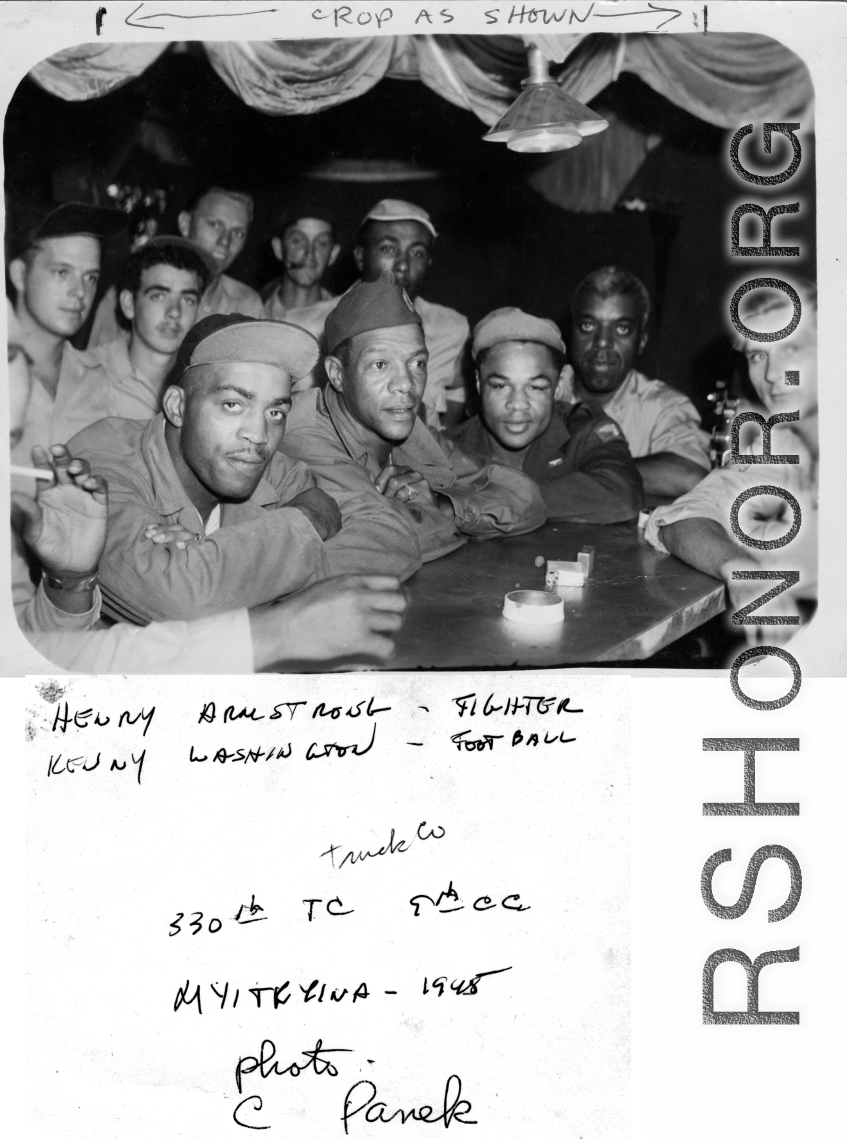 African-American servicemen in a club or bar in Myitkyina in 1945, during WWII. Stars in pre-army life, the fighter Henry Armstrong and the football player Kenny Washington get full attention from surrounding fans.