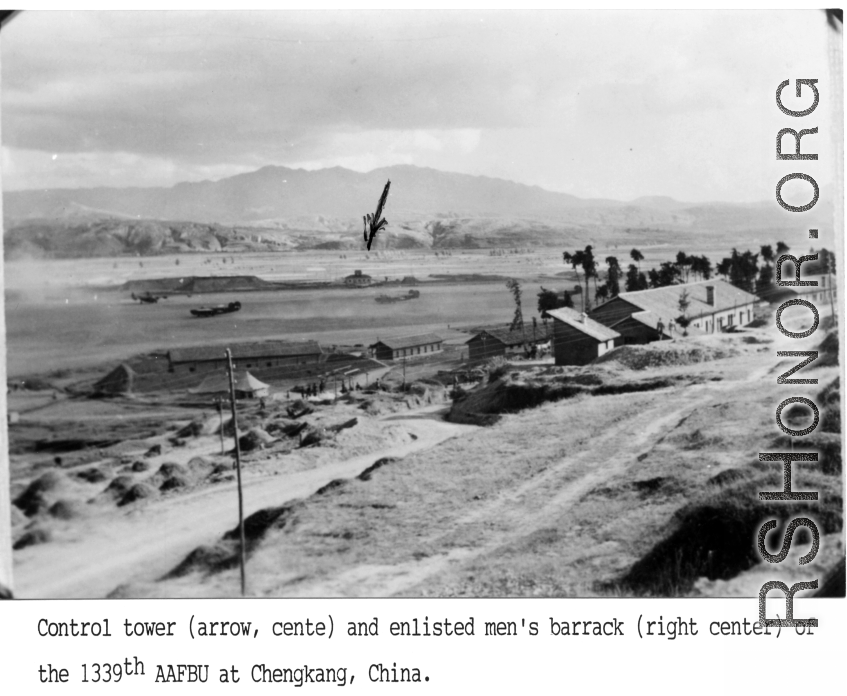 Control tower (arrow, center) and enlisted men's barrack (right center) of the 1339th AAFBU at Chengkung, Yunnan province, China. Four B-24s are scattered around the field.