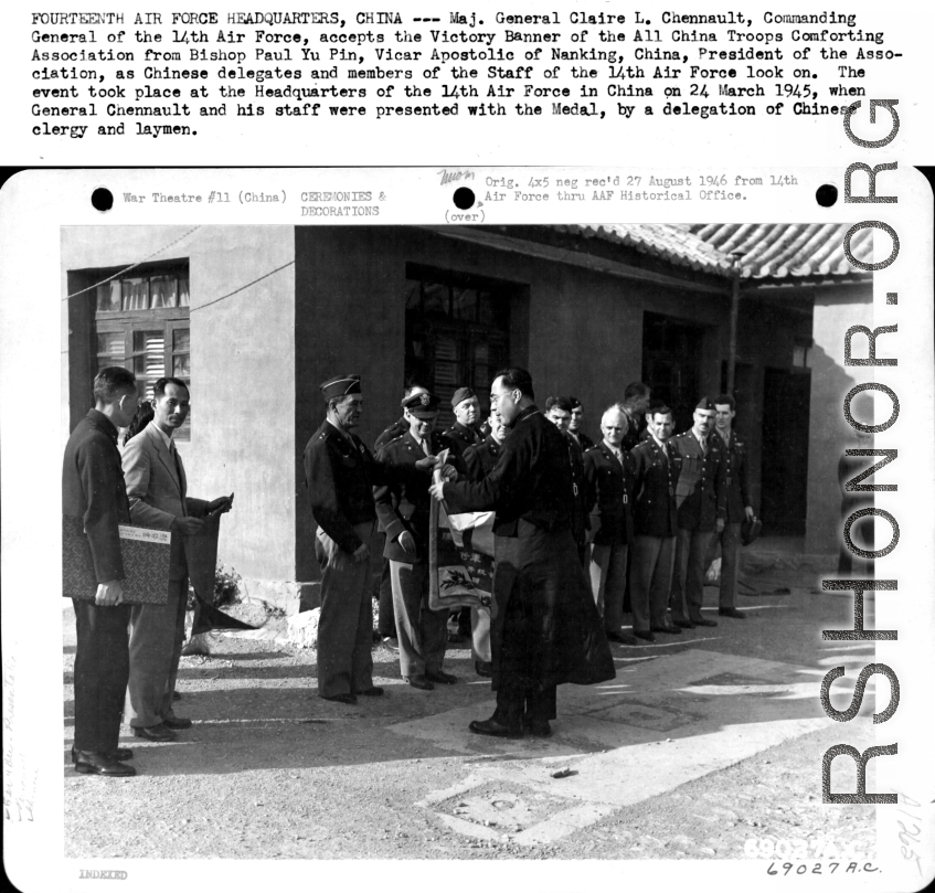 Major General Claire L. Chennault accepts the Victory Banner of the All China Troops Comforting Association from Bishop Paul Yu Pin, as Chinese delegates and members of the staff of the 14th Air Force look on. March 24, 1945