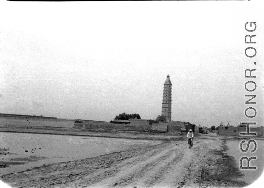 A man bicycles on dusty road near the Chengtian Temple Pagoda in Yinchuan, in northern China, during WWII.   二战期间银川的承天寺塔。