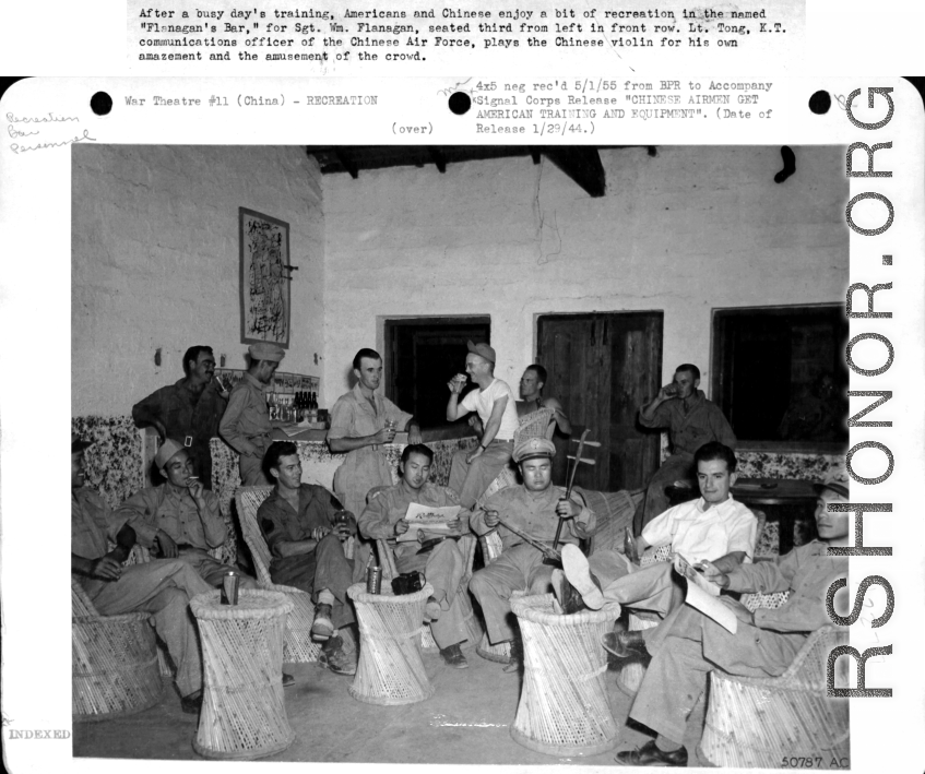 Americans and Chinese enjoy a bit of recreation in "Flanagan's Bar," named for Sgt. Wm. Flanagan, seated third from the left in front row. Lt. Tong, K. T, communications officer for the Chinese Air Force, plays the Chinese violin (二胡).  Image courtesy of Tony Strotman.