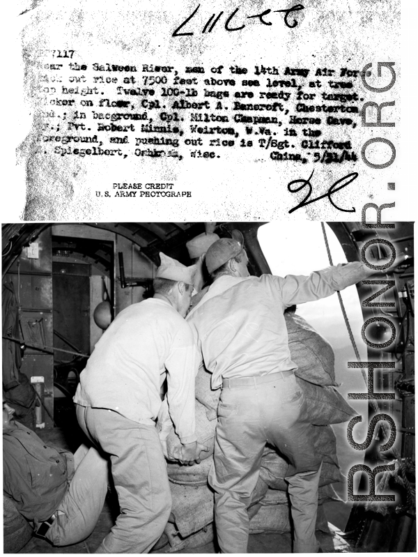 An airdrop of  rice supplies near the Salween River by 14th Air Force crew, from 7500 feet elevation. Twelve 100-lb bags are readied, then pushed out. Kicker on floor is Cpl. Albert A. Baneroft, and on the background Cpl. Milton Chapman, foreground is Pvt. Robert Minnis, and pushing out rice is T/Sgt. Clifford Spiegelbert.