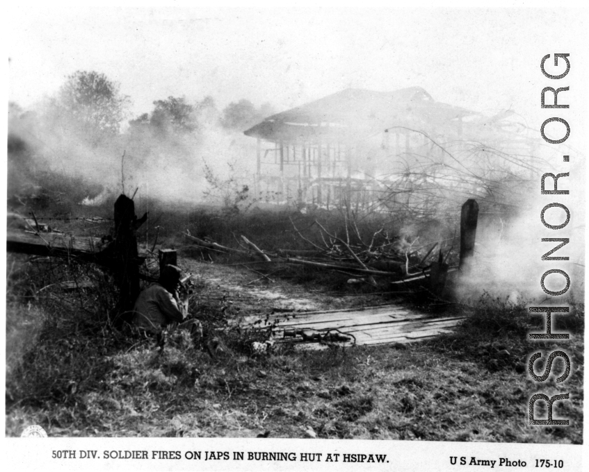 50th Division soldiers fires on Japanese position in burning hut at Hsipaw, Burma, during WWII.