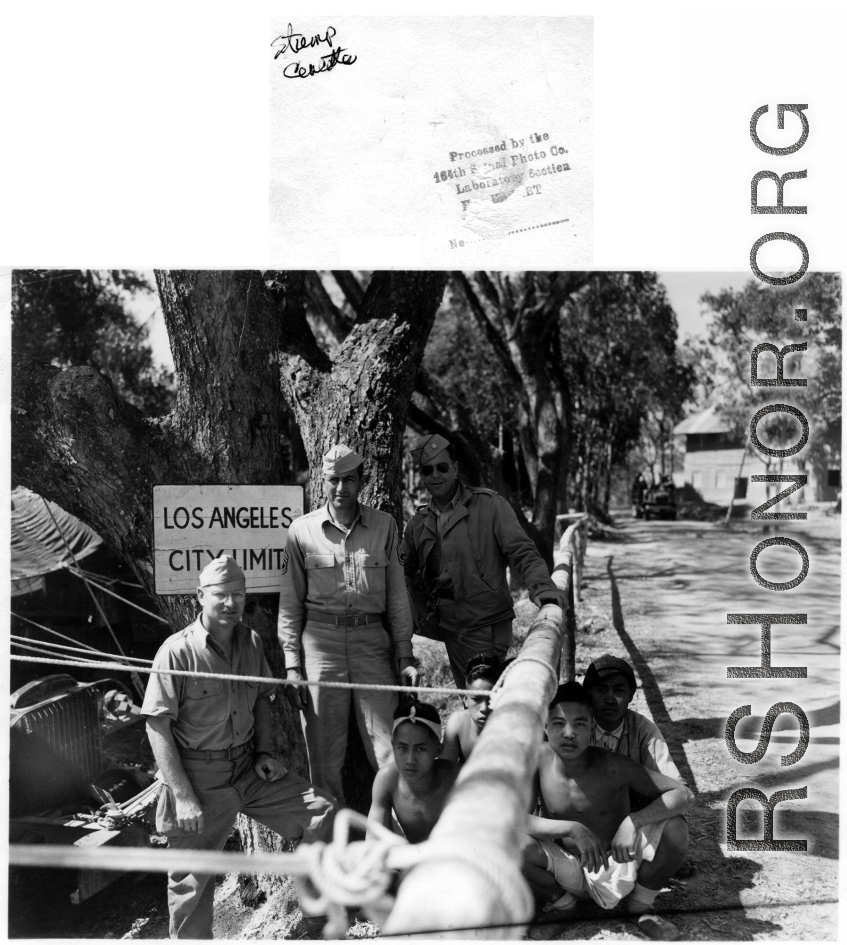 GIs pose with squatting men in the CBI, likely Japanese POWs.  Photo processed by 164th Signal Photographic Company.