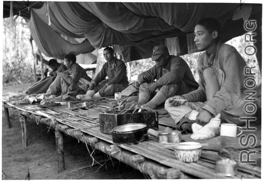 Nationalist soldiers convalesce on a bamboo platform covered in mosquito netting during WWII.