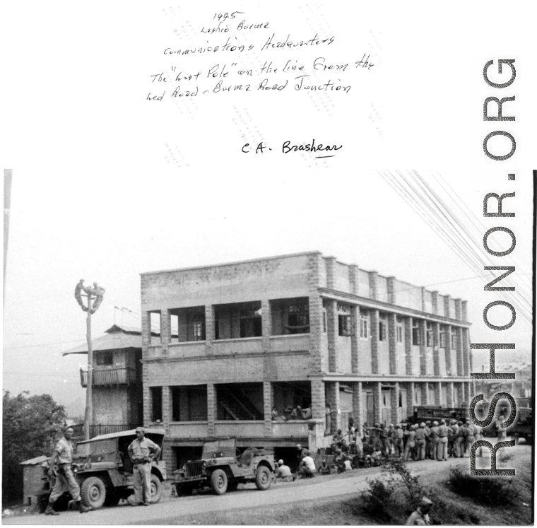 Allied communications HQ at Lashio, Burma, in 1945, with two technicians up on pole working on line from Ledo-Burma Road junction.  Photo from C. A. Brashear.