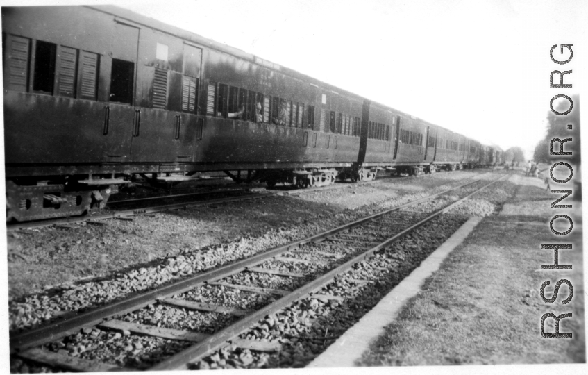 A long row of passenger train cars in India, during WWII.  In the CBI.