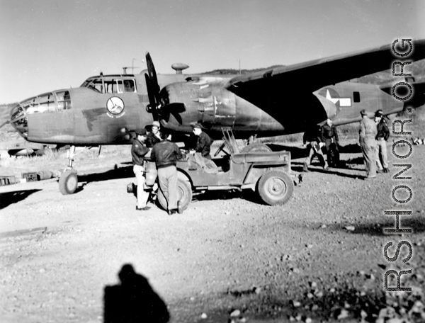 Early morning at Yankai Air Base, China. Aircrew, in flight jackets, and maintenance personnel of the the 491st Bomb Squadron prepare for a mission. This is probably a newly arrived aircraft, because the B-25D, no mission symbols are displayed below the pilot\'s window. Photo was probably taken in the spring of 1944.