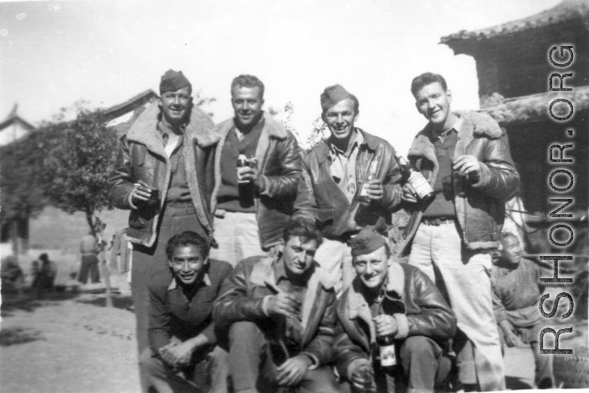 GIs pose with bottles of beer in China during WWII: "This Is A Bunch Of 396th Party Boys Enjoying A Little Brew At Luliang,China. Kneeling: Chinese man, Winter, and Walker. Standing: Gerdsen, Garver, Rush, and Tacey."