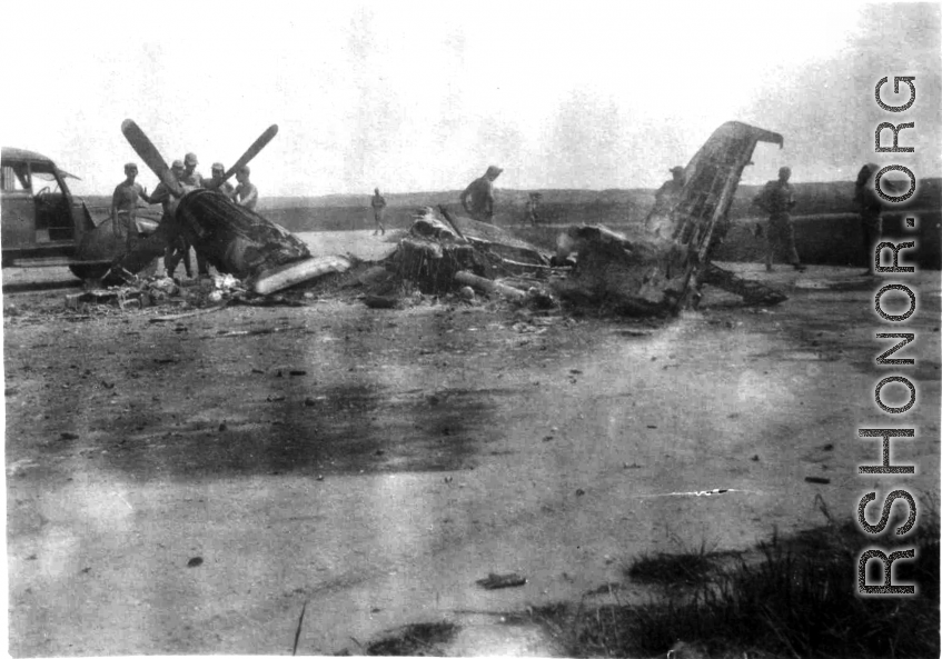 Soldiers look at a burned P-51 fighter in China during WWII.