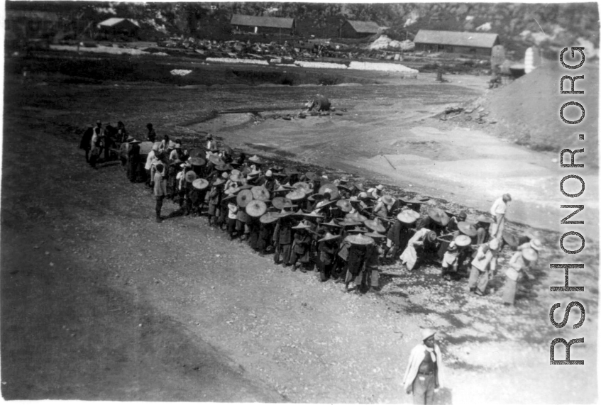 Chinese laborers pull a large concrete roller at an American base in Guangxi, China, during WWII.