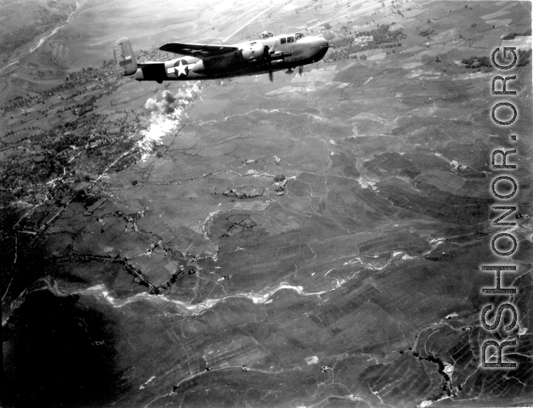 Smoke rises on the ground, behind B-25 #437 after an attack by American B-25s in either SW China, Indochina, or the Burma area.  This might be fairly close to Tengchong in China.