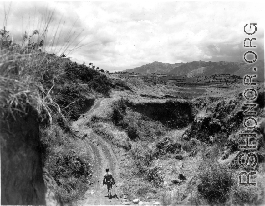 An American serviceman walking alone in the countryside in Yunnan province, China, carbine in hand. During WWII.