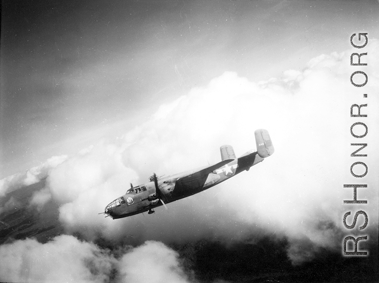 B-25 Mitchell bomber #448 in flight in the CBI, in the area of southern China, Indochina, or Burma.