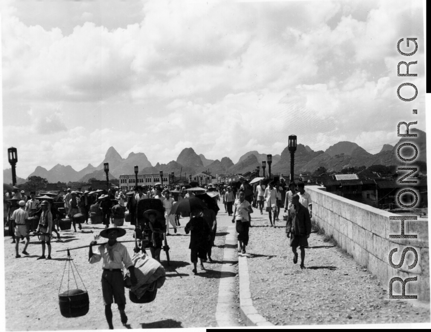 Bustling city life on a bridge in Guilin during WWII.