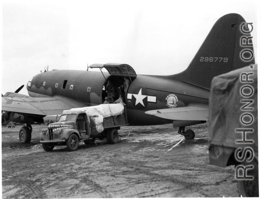 A C-46 cargo plane of the Air Transport Command (ATC), tail number #296779, being unloaded (or loaded) in China during WWII.