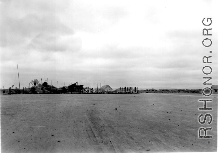 Burned building and fuel barrels at an American base, likely at Guilin, China.