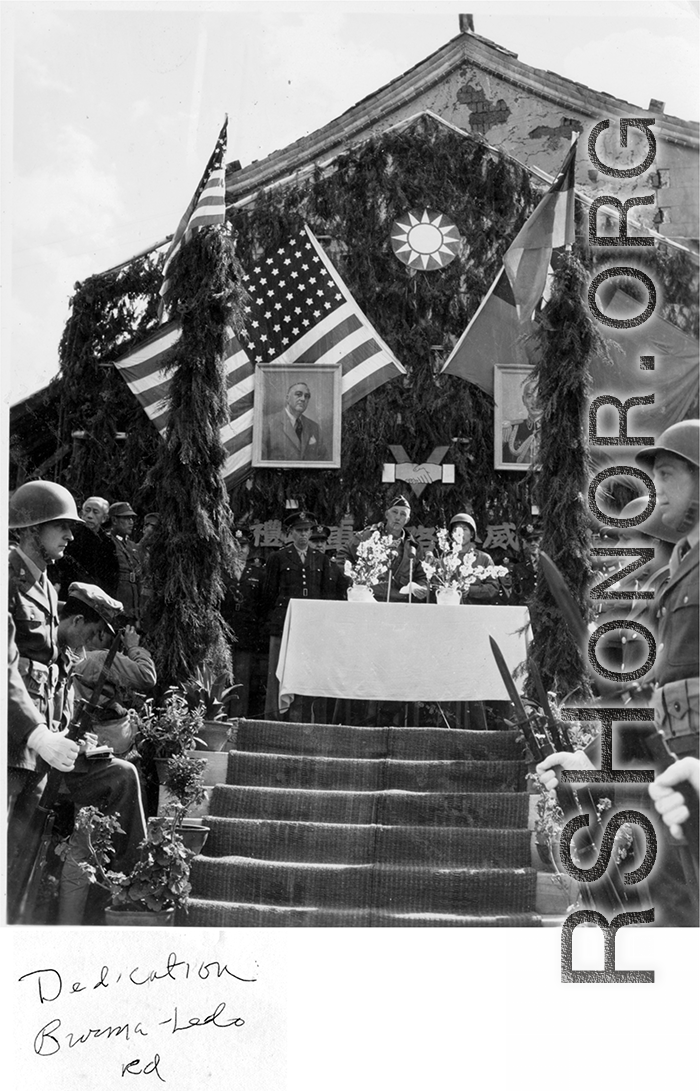 Burma Road dedication ceremony in Kunming, China, on February 4, 1945, during WWII. Review of first convoy (or one of the first convoys) to reach China. General view of the stage and reviewing party, with American and Chinese dignitaries, soldiers, and civilian VIPs. An American band plays, and an honor lines on both sides of the center carpet stand in formation.  Official dignitaries at the ceremony included, on the Chinese side, such figures as General Lung Yun, Governor of Yunnan Province,  Gen. Wang Yu-