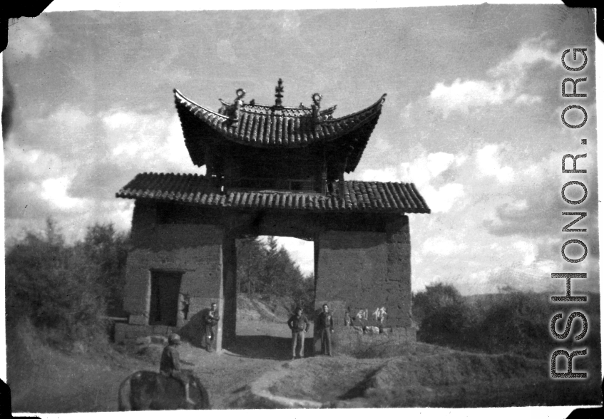 Three American servicemen strolling the countryside near Yangkai, Yunnan, China.  A local boy rides a cow or oxen in front.  Walter S. Polchlopek, Corporal, was lost on May 20, 1944, over the sea near the south east coast of China, after a B-24 mission to strike Japanese shipping.