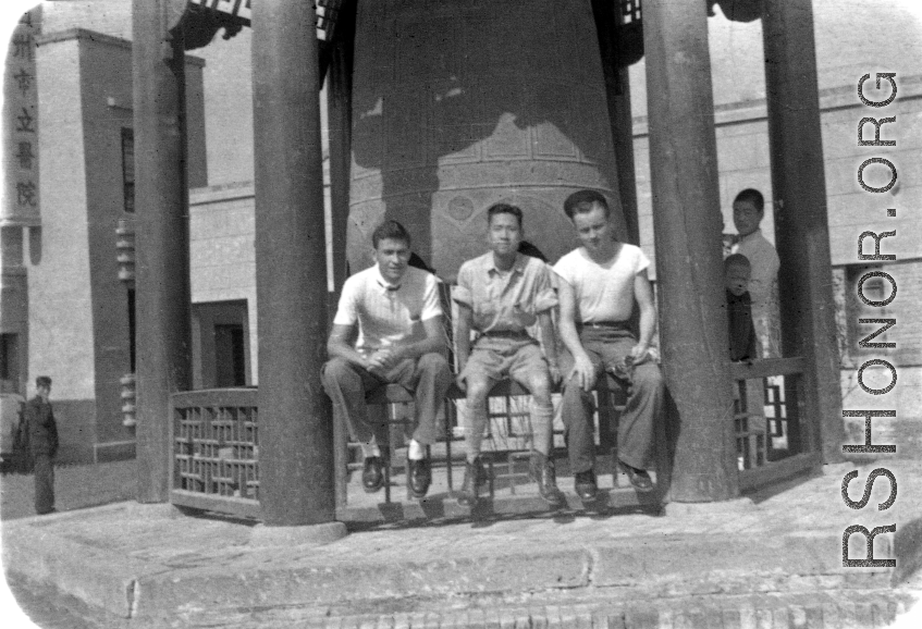 GIs of SACO and a Chinese soldier sit in front of a large cast bell, next to the Lanzhou City Hospital (兰州市立医院) in Gansu province, China, during WWII.