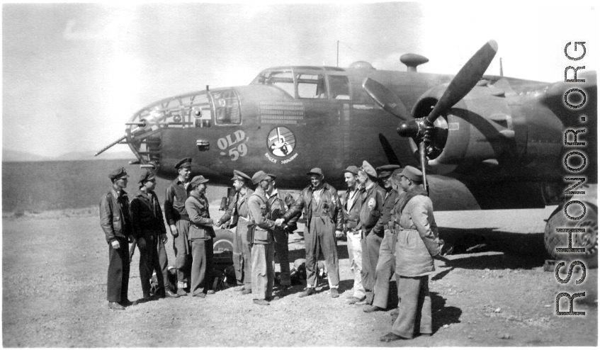 Maj. Joseph Callaway, 491st Bombardment Squadron C.O., Capt. Robert Ebey (pilot - Old 59) and 1Lt Paul Sjoberg (copilot) observe as well-wishers offer a safe journey to other crew members of "Old 59" (in flight suits), prior to departing Yangkai for the USA in March 1944.