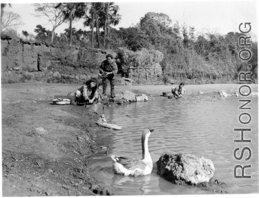 Villagers do the chores on shore of village pond. Probably near Yangkai, 1945.  From the collection of Frank Bates.