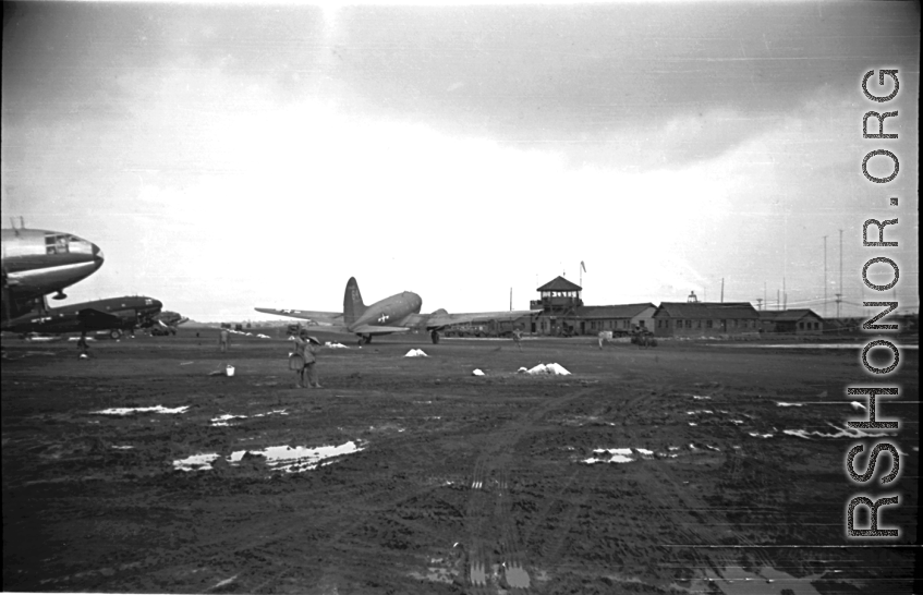 Base, planes, and control Tower at an American base in China during WWII. Local people in Yunnan province, China, most likely around the Luliang air base area.