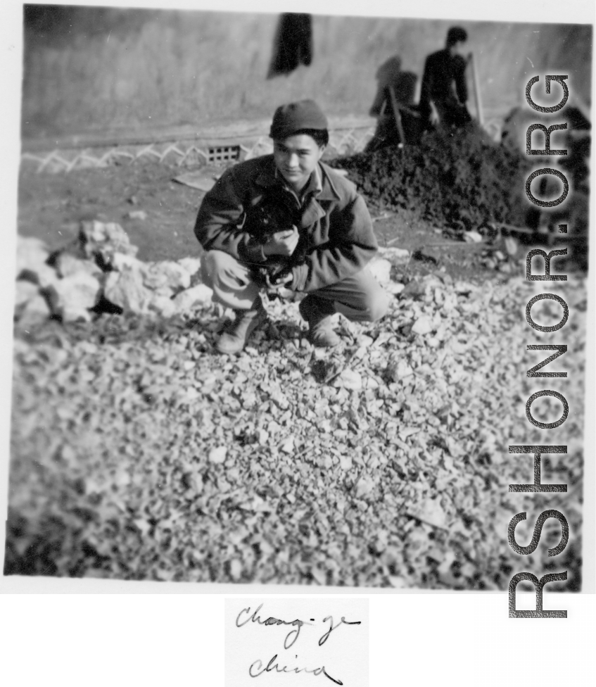 Probably a local boy in China, holding a small animal. During WWII.