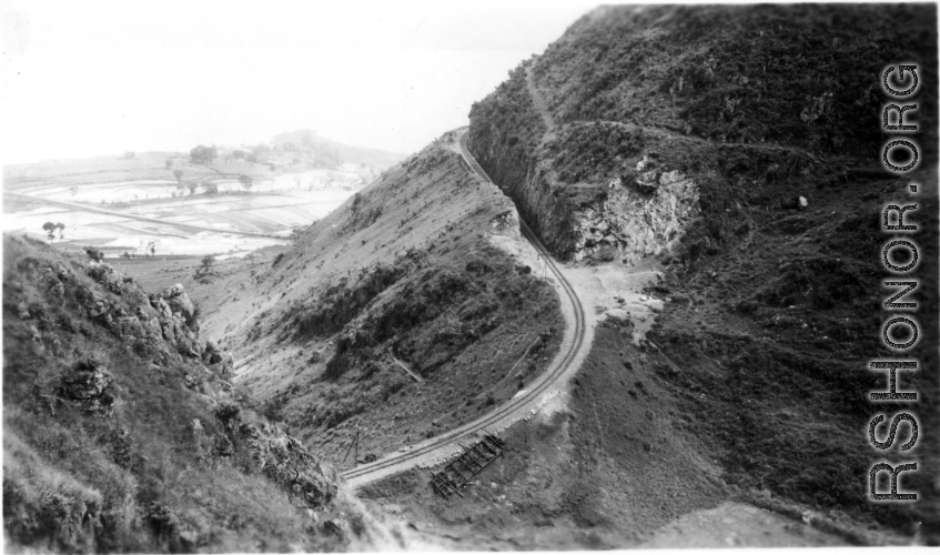 A train track--with a flipped flatcar--in Yunnan province, China. Near Camp Schiel. Yangzonghai Lake is in the background.  During WWII.