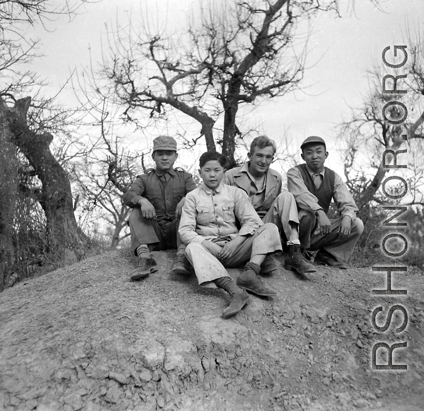 Yunnan (China), three young men employed as housekeepers and launderers sitting with Bert Krawczyk: "These are three houseboys from the airbase at Luliang. Houseboys were provided by the Chinese government under a reverse lend-lease program. The China War Area Service Command administered the program. This command was set up by Madame Chiang Kai-Shek to take care of the food and housing needs of American servicemen in China, who were considered guests by the Chinese government."