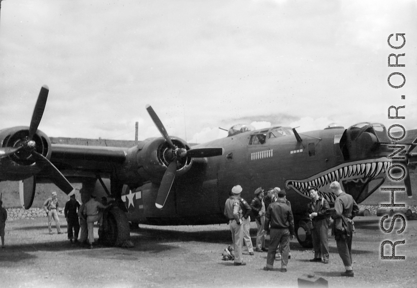 A shark-mouth B-24, the mouth having a unique curl at the back, in a revetment in SW China, likely Sichuan, during WWII. This is a later model B-24 as indicated by the nose turret with two .50 cal machine  guns.